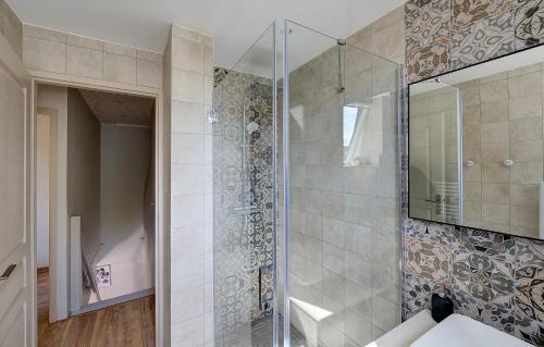 une salle de bain avec une douche avec une porte vitrée dans l'établissement Gîte Le Paul Bert - centre ville-parking gratuit, à Tours