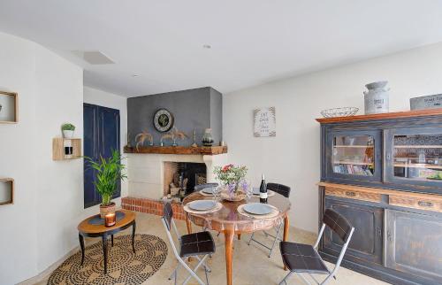 une salle à manger avec une table et des chaises et une cheminée dans l'établissement Gîte Le Paul Bert - centre ville-parking gratuit, à Tours