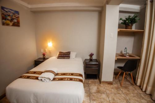 a hotel room with two beds and a desk at RUMIQOLQA Machupicchu Hotel in Machu Picchu