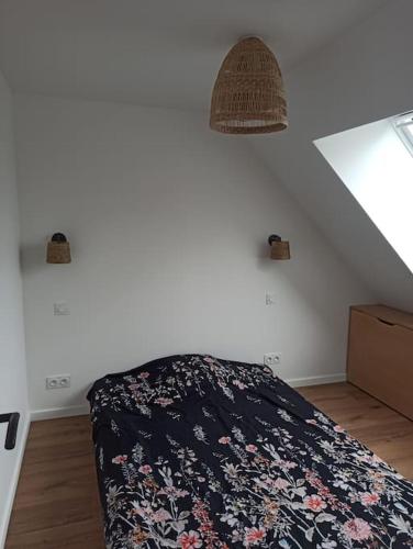 1 Schlafzimmer mit einem Bett mit einer schwarzen Blumenbettdecke in der Unterkunft Appartement 2 chambres in Lesneven