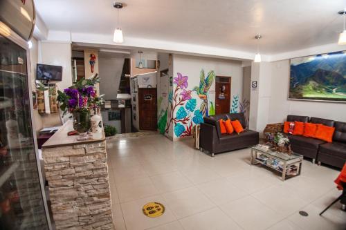 a living room with two couches and a kitchen at RUMIQOLQA Machupicchu Hotel in Machu Picchu