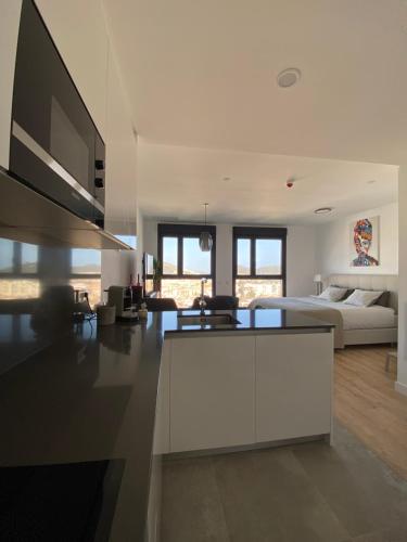 Ein weißes Zimmer mit einem Bett und einem Wohnzimmer. in der Unterkunft Urban Sky Views over Malaga in Málaga