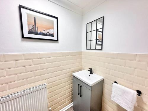 a white bathroom with a sink and a mirror at Steel Town Lodge - Comfy Home in Port Talbot with Hot Tub, Sky Sports & Dart Board in Port Talbot