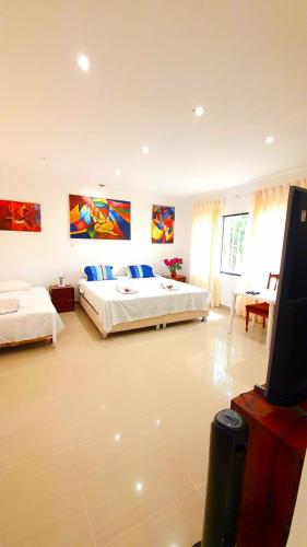 a bedroom with two beds and a flat screen tv at Edelmon't Beach in Los Órganos