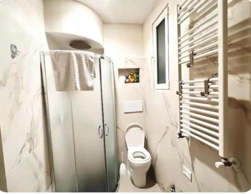 Un baño blanco con inodoro y ducha. en Central Station Studio Flat, en Milán