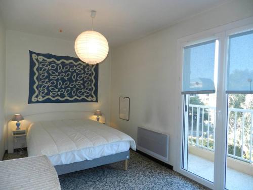 une chambre avec un lit et une grande fenêtre dans l'établissement Appartement avec Piscine et Terrasse, Proche Plage - 4 Couchages, Parking, Animaux Acceptés - FR-1-251-808, au Lavandou