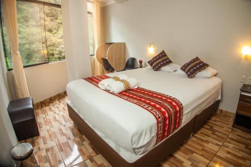 a bedroom with a bed in a room with a window at RUMIQOLQA Machupicchu Hotel in Machu Picchu