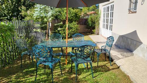 a table and chairs with an umbrella in a yard at Casa de vacaciones, alquiler temporario en La Falda in La Falda