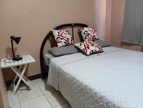 1 dormitorio con 1 cama y 1 lámpara en una mesa en Cabinas Miramar, una casa SOLO para ti, en San Isidro