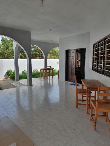 uma sala de jantar com uma mesa e cadeiras num quarto em Delalie Hotel em Palimé