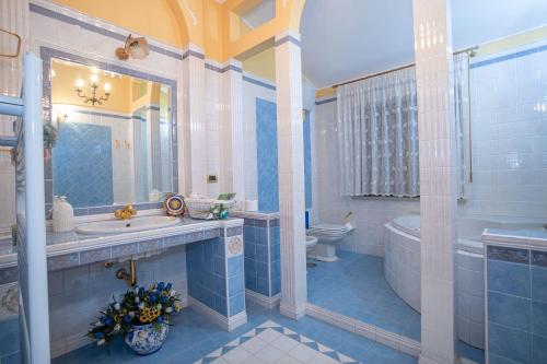 a bathroom with a tub and a sink and a toilet at Il Giardino dei Tigli Villa Bianco in Rotondi