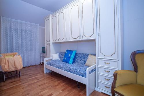 a bedroom with a white cabinet and a blue couch at Il Giardino dei Tigli Villa Bianco in Rotondi