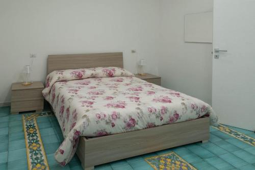una camera da letto con un letto con copriletto floreale di Let It B&B Apartment a Salerno
