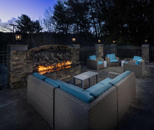 eine Terrasse mit Sofas und einem Steinkamin in der Unterkunft Hampton Inn Asheville-Tunnel Road in Asheville