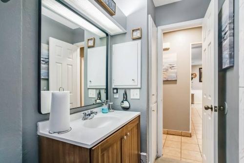 La salle de bains est pourvue d'un lavabo et d'un grand miroir. dans l'établissement Fire Pit 15 min to Lackland AFB & 3 min to St Mary’s University, à San Antonio