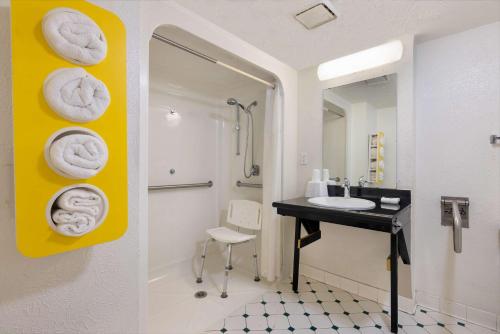 łazienka z umywalką i ręcznikami na ścianie w obiekcie Motel 6-Beaumont, TX w mieście Beaumont