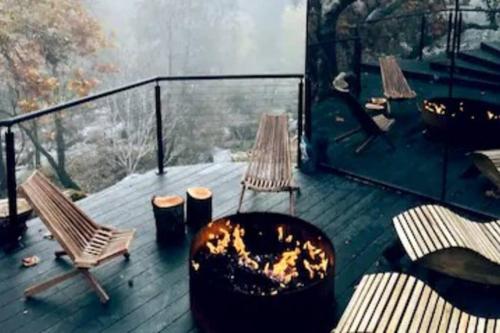 a deck with two chairs and a fire pit at Paradise Ranch Inn- Awake House Hot Tub,Sauna in Three Rivers
