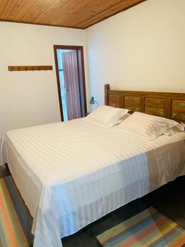 a bedroom with a large white bed and a window at Pousada Serra Morena in Serra do Cipo