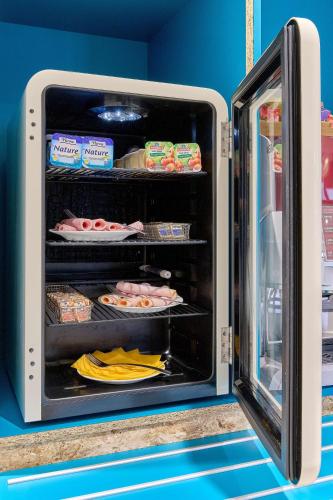 an open refrigerator with food inside of it at Kyriad Direct Moulins Sud - Yzeure in Moulins