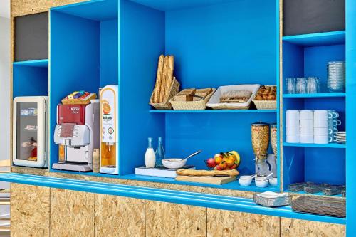 a blue shelf with food and other items on it at Kyriad Direct Moulins Sud - Yzeure in Moulins