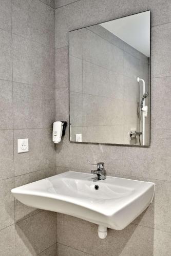 a white sink in a bathroom with a mirror at Kyriad Direct Moulins Sud - Yzeure in Moulins