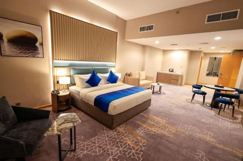 une chambre d'hôtel avec un lit et un salon dans l'établissement Best Western Premier M Four Hotel, à Dubaï