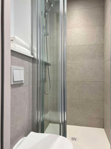 a bathroom with a glass shower with a toilet at Kyriad Direct Moulins Sud - Yzeure in Moulins