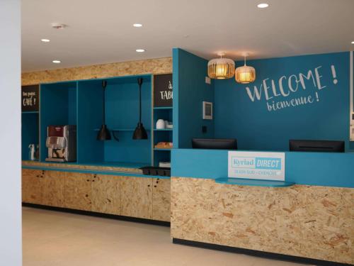 a lobby with a blue wall with a welcome sign at Kyriad Direct Moulins Sud - Yzeure in Moulins