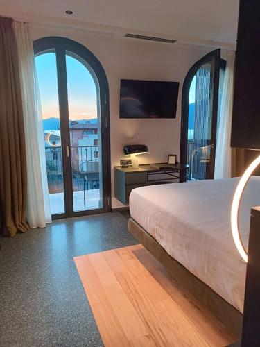 a bedroom with a bed and a view of a balcony at Hotel Ristorante Al Caminetto WorldHotels Crafted Adults Only in Torri del Benaco