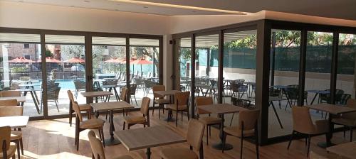a restaurant with tables and chairs and a pool at Hotel Ristorante Al Caminetto WorldHotels Crafted Adults Only in Torri del Benaco