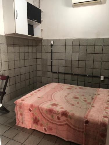 Una habitación con una cama con una manta rosa. en Vegaspub1600 en Campina Grande