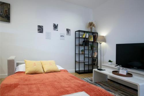 une chambre avec un lit et une télévision à écran plat dans l'établissement Warm 2 bedrooms apartement - c38, à Paris