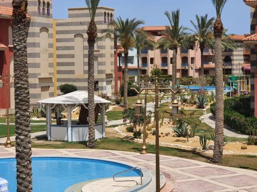 a resort with a pool and palm trees at Porto Matroh Tours in Marsa Matruh