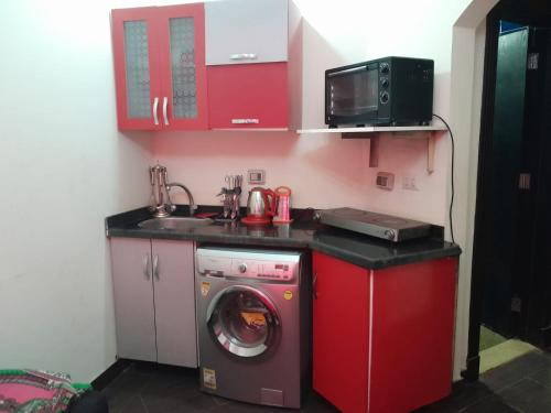 a kitchen with a washing machine and a microwave at Porto Matroh Tours in Marsa Matruh