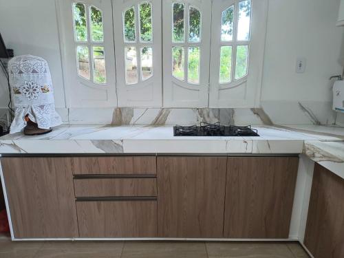 ジャコビナにあるSitio Recanto da Felicidadeのカウンター付きのキッチン、窓2つが備わります。