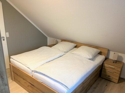 Cette petite chambre comprend un lit avec des draps blancs. dans l'établissement Apartment FriesenLück, à Bockhorn