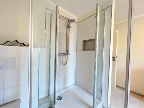 een douche met glazen deuren in de badkamer bij Apartment FriesenLück in Bockhorn