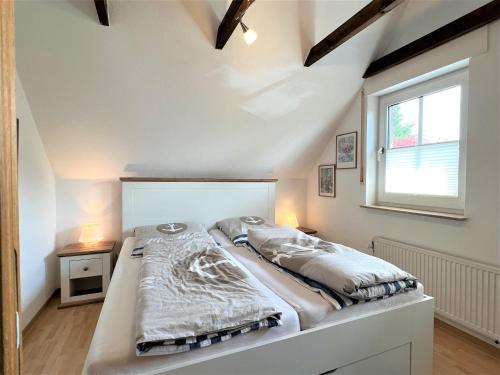 a bed in a room with a window at Haus Auszeit, Bordumer Str 16A, 70qm in Dangast