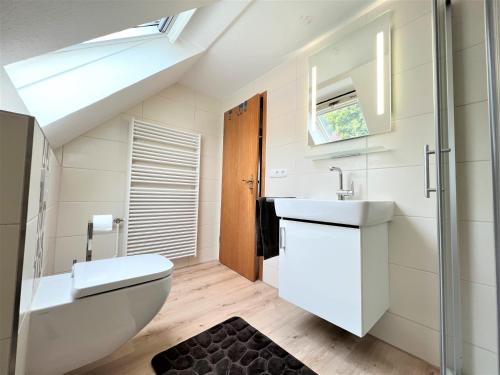 a bathroom with a sink and a toilet at Haus Auszeit, Bordumer Str 16A, 70qm in Dangast