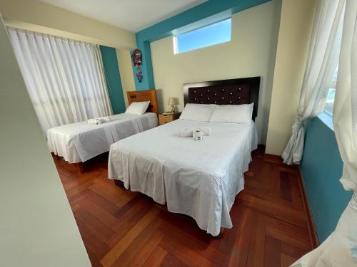 a bedroom with two beds with white sheets at MISKI PUÑUY - Dulces sueños HOSPEDAJE in Cusco