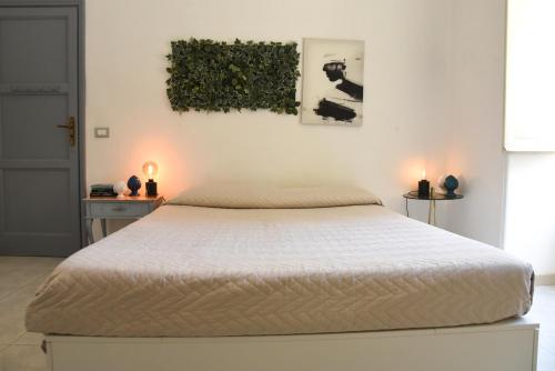 een slaapkamer met een bed met twee kaarsen aan de muur bij Viabalduini2 in Lecce