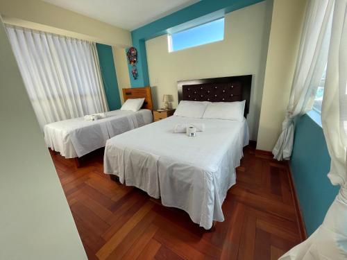 a bedroom with two beds with white sheets at MISKI PUÑUY - Dulces sueños HOSPEDAJE in Cusco
