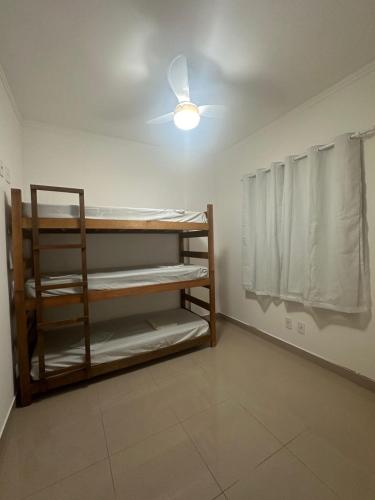 a room with bunk beds and a ceiling fan at Apto Apólo - 3 dorm Wifi in São Carlos