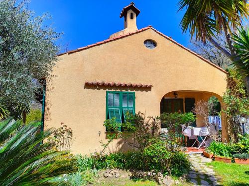 a house with a green window and a table at L'Uliveto D'Argento in Finale Ligure