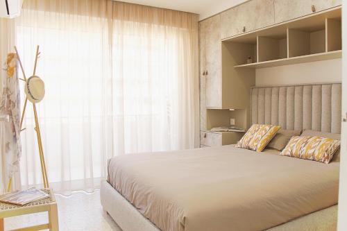 une chambre avec un grand lit et une grande fenêtre dans l'établissement Le charme de Cannes, à Cannes