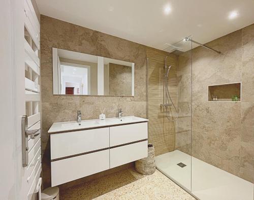 une salle de bain avec un lavabo et une douche dans l'établissement Le charme de Cannes, à Cannes