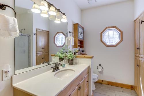 uma casa de banho com um lavatório, um WC e um espelho. em Family-Friendly Cabin By Golf Course and Marina em Holiday Island