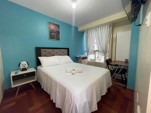 a bedroom with a bed with a blue wall at MISKI PUÑUY - Dulces sueños HOSPEDAJE in Cusco