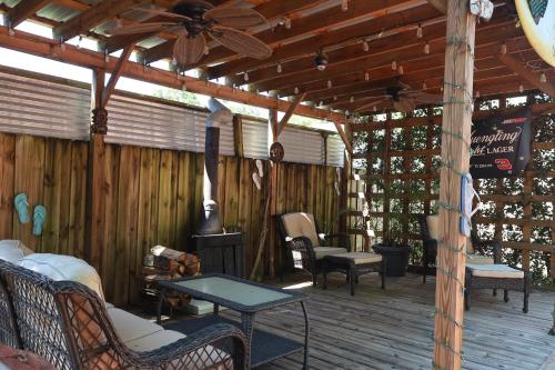 a wooden porch with a fireplace and a ceiling fan at 3 Bdrms & Private Backyard Tiki Courtyard & more in Homosassa Springs