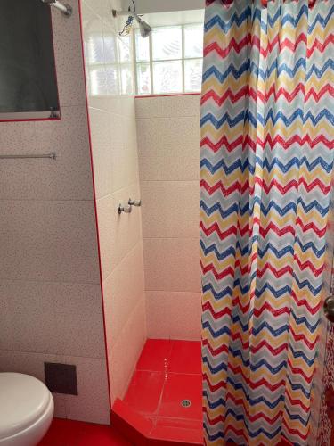 a bathroom with a shower with a colorful shower curtain at MISKI PUÑUY - Dulces sueños HOSPEDAJE in Cusco